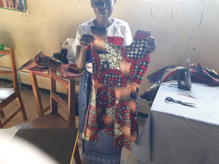 Eine Näherin zeigt ihr Werk.